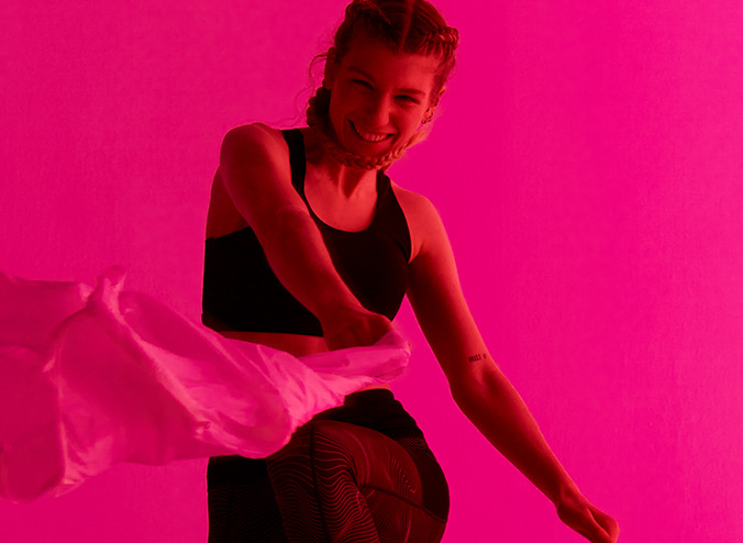 Person in Superdry clothing looking directly at camera lens with pink background